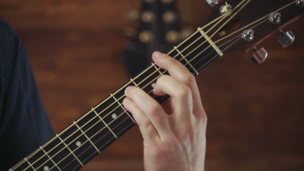 Cerrar mans mano tomando acordes en la guitarra acústica cámara lenta — Vídeo de stock