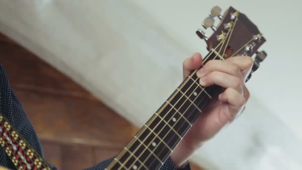 Dicht tot mans hand nemen van akkoorden op akoestische gitaar slow motion — Stockvideo