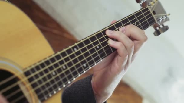 Close-up mannenhand nemen akkoorden op akoestische gitaar slow motion — Stockvideo