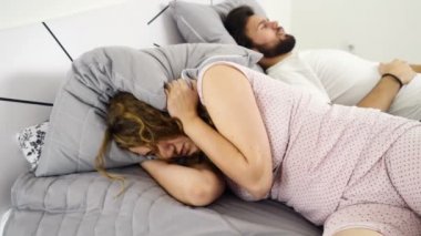 kadın bir adam ağır çekim ile uyurken başını yastığın altına saklanıyor