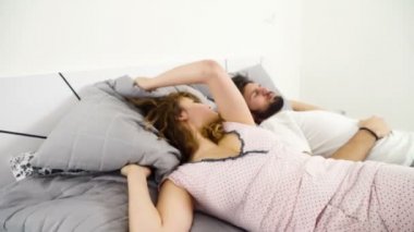 kadın bir adam ağır çekim ile uyurken başını yastığın altına saklanıyor