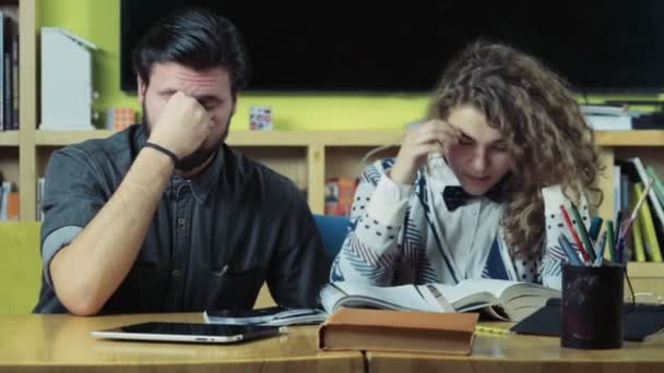 Casal de alunos cansados sentados na sala de aula câmera lenta — Vídeo de Stock