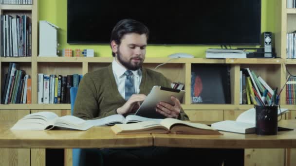 Estudiante masculino usando una tableta mientras estudia cámara lenta — Vídeo de stock