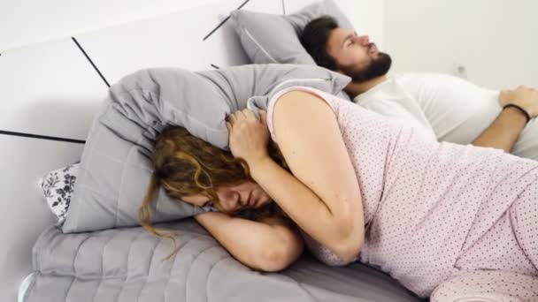 Wanita menyembunyikan kepalanya di bawah bantal saat tidur dengan seorang pria gerakan lambat — Stok Video