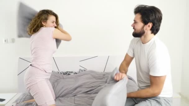 Divertido pareja almohada lucha en cama cámara lenta — Vídeos de Stock