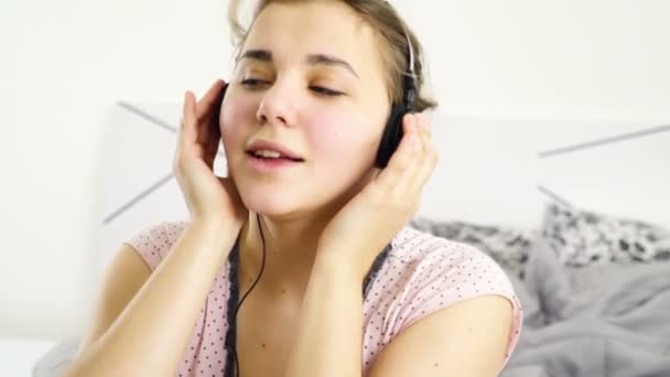 Vrouw luisteren naar muziek in hoofdtelefoon thuis slow motion — Stockvideo