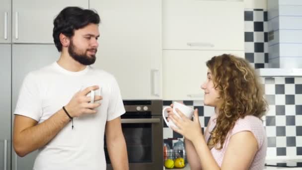 Sonriente pareja bebiendo té en la cocina cámara lenta — Vídeo de stock