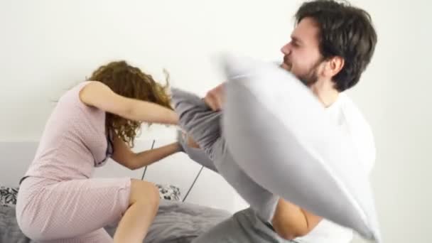 Divertido pareja almohada lucha en cama cámara lenta — Vídeos de Stock