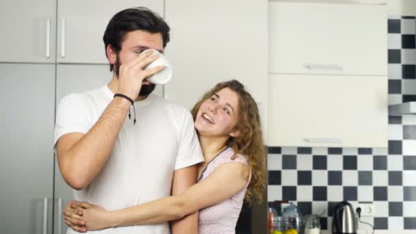 Sorrindo casal beber chá na cozinha câmera lenta — Vídeo de Stock