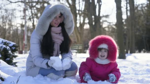 Madre e hija vomitando un poco de nieve cámara lenta — Vídeo de stock