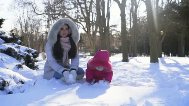 Мать и дочь бросают немного снега замедленной съемки — стоковое видео