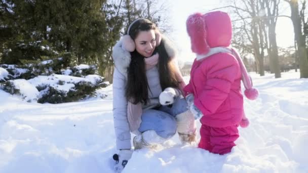 Мать и дочь играют в замедленной съемке снега — стоковое видео