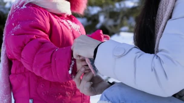 Мать надевает перчатку на дочь замедленная съемка руки — стоковое видео