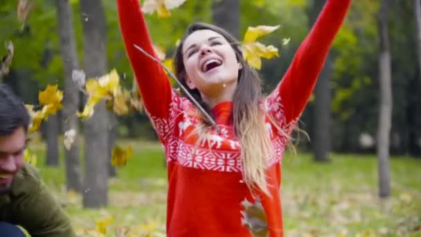 Mladý pár zvracel spadané listí v parku slow motion — Stock video