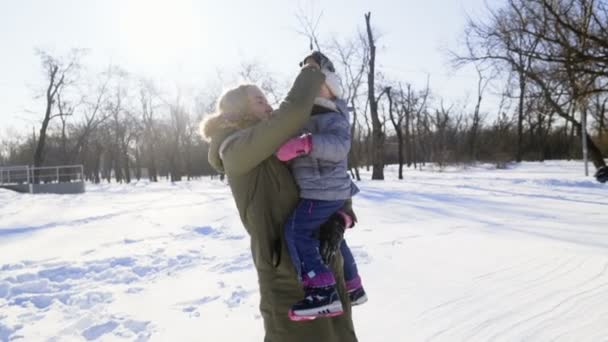 Madre jugando con su hija en el parque de invierno cámara lenta — Vídeos de Stock