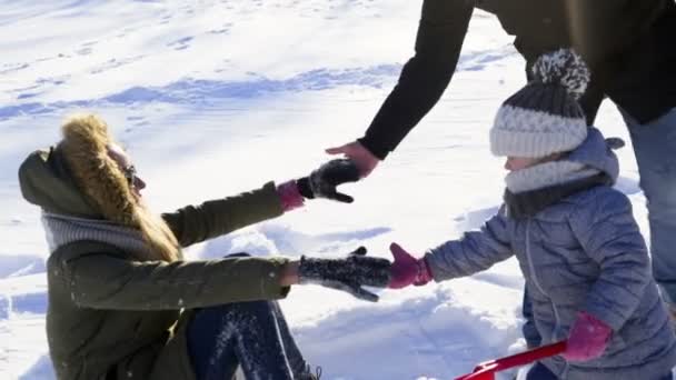 Família brincando na neve no parque câmera lenta — Vídeo de Stock
