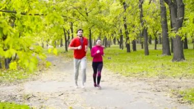 gülümseyen çift sonbahar park ağır çekimde koşu