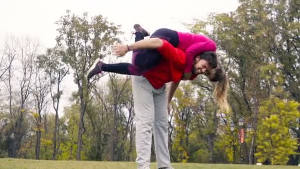 Joven pareja divirtiéndose mientras haciendo deportes en el parque cámara lenta — Vídeos de Stock