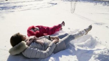 Anne ve kızı kar yavaş hareket üzerinde eğleniyor