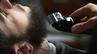 Sakal kesme makinesi yavaş hareket istemcinin yakın çekim dusunu berber