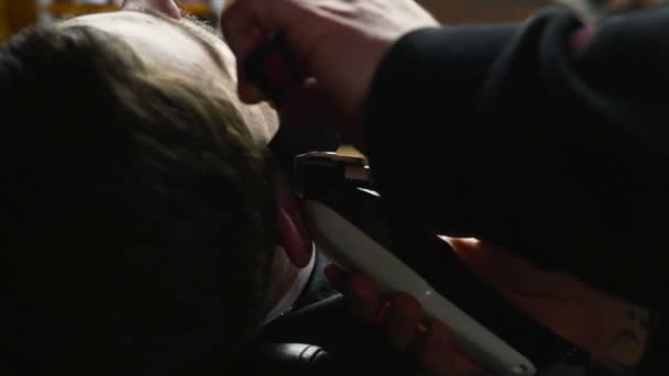 Peluquero afeita la barba del cliente con el clipper cámara lenta — Vídeos de Stock