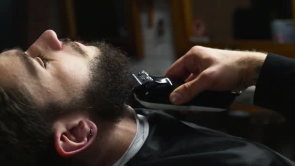 Peluquero afeita la barba del cliente con el clipper cámara lenta — Vídeos de Stock