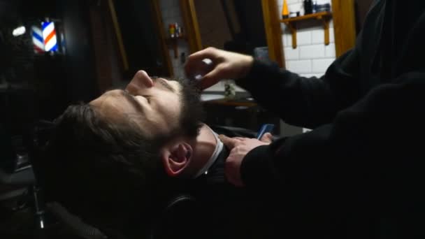 Barber cleans the chin of the client with brush slow motion — Stock Video