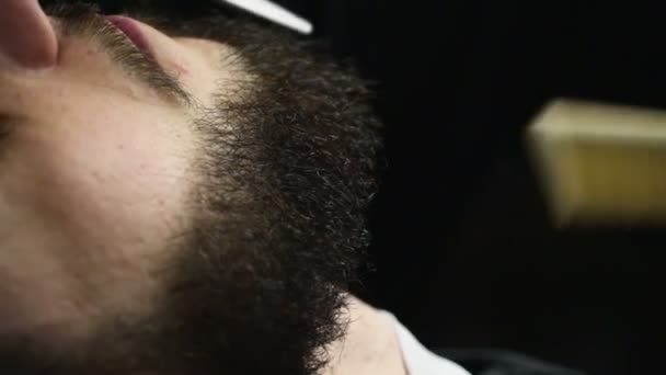 Barber cuts the beard hair of the client with scissors slow motion — Stock Video