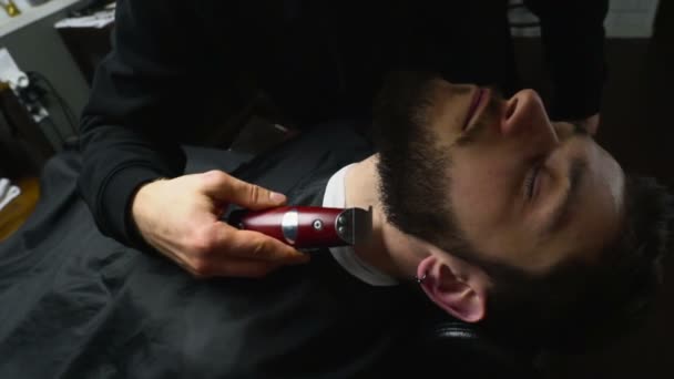 Barber holí vousy klienta s sekačky Zpomalený pohyb — Stock video