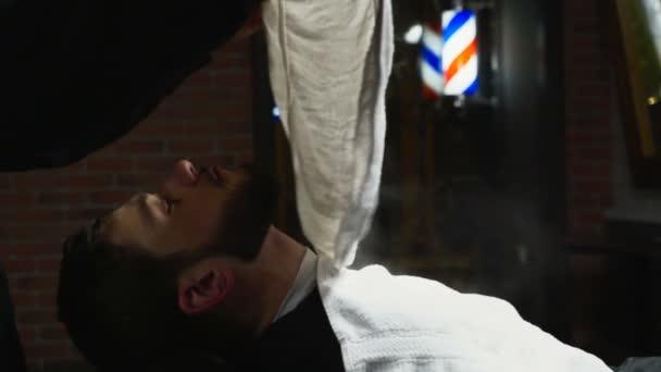 Close up barber puts a hot towel on male face slow motion — Stock Video