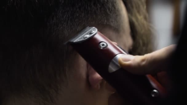 Peluquero corta el cabello del cliente con trimmer cámara lenta de cerca — Vídeos de Stock