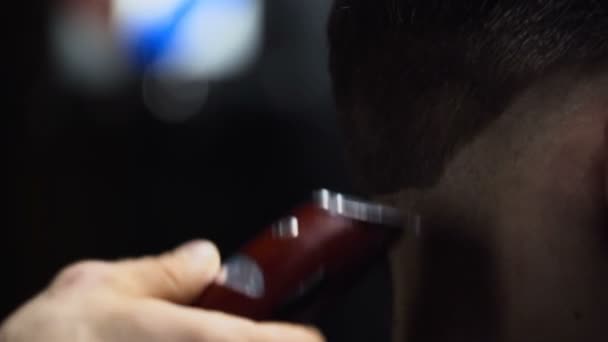 Barber coupe les cheveux du client avec tondeuse au ralenti fermer 