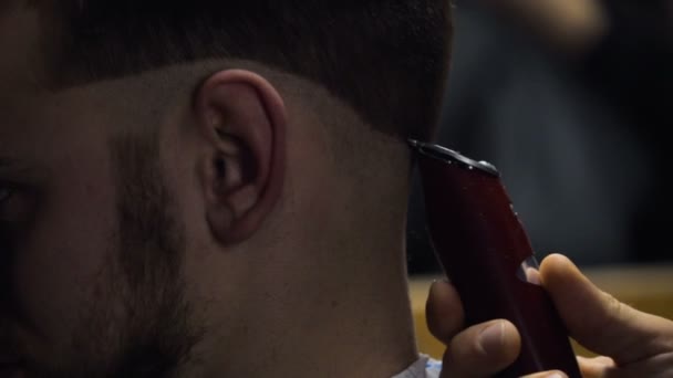 Barber coupe les cheveux du client avec tondeuse au ralenti fermer — Video