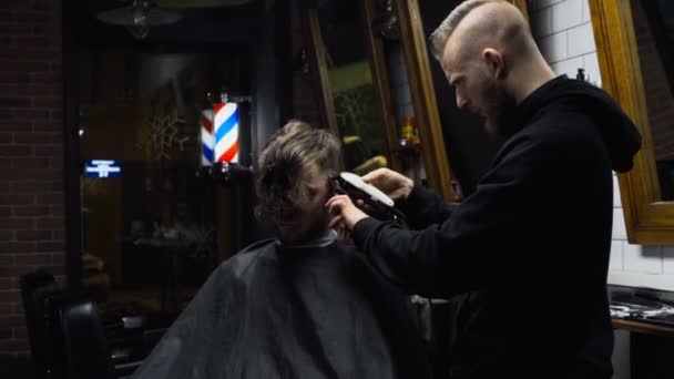 Κουρέας κόβει τα μαλλιά του πελάτη με clipper αργή κίνηση — Αρχείο Βίντεο