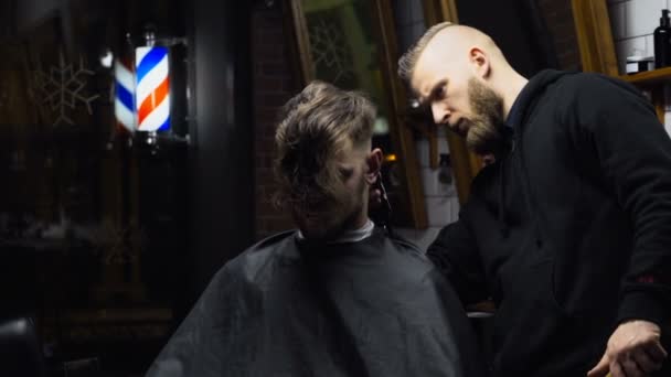 Barber coupe les cheveux du client avec tondeuse au ralenti — Video