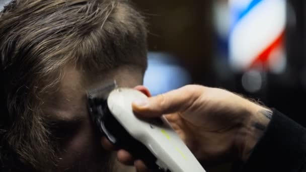 Kapper bezuinigingen de haren van de klant met clipper slowmotion close-up — Stockvideo