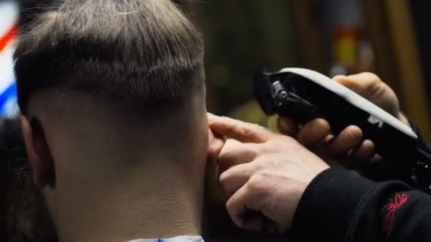 Barbeiro corta o cabelo do cliente com clipper câmera lenta de perto — Vídeo de Stock