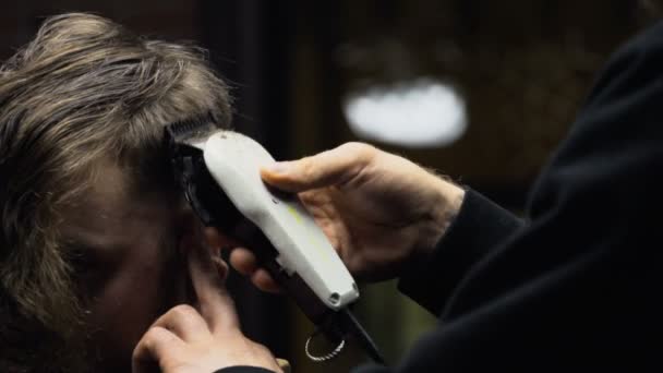 Barberare nedskärningar håret på klienten med clipper ultrarapid närbild — Stockvideo