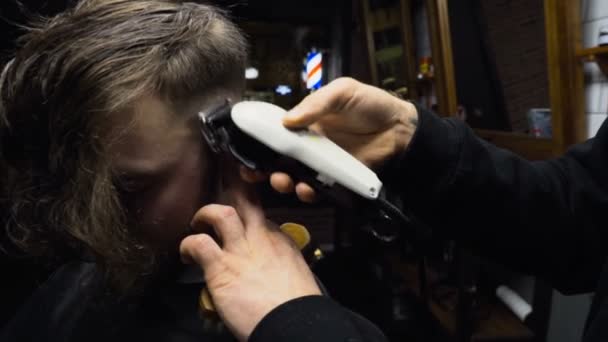 Kapper bezuinigingen de haren van de klant met clipper slowmotion close-up — Stockvideo