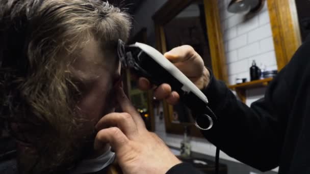 Barberare nedskärningar håret på klienten med clipper ultrarapid närbild — Stockvideo