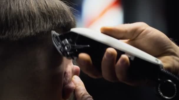 Barbiere taglia i capelli del cliente con clipper slow motion da vicino — Video Stock