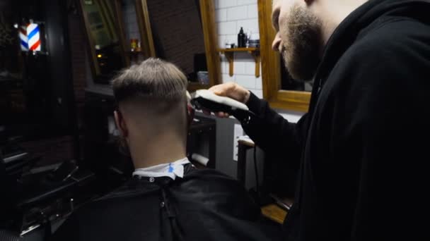 Barber coupe les cheveux du client avec tondeuse au ralenti — Video