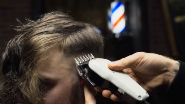 Barber coupe les cheveux du client avec tondeuse au ralenti gros plan — Video