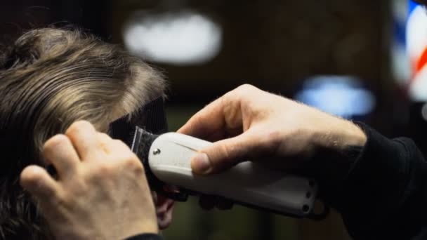 Barber zastřihne vlasy klienta s clipper zpomalené — Stock video