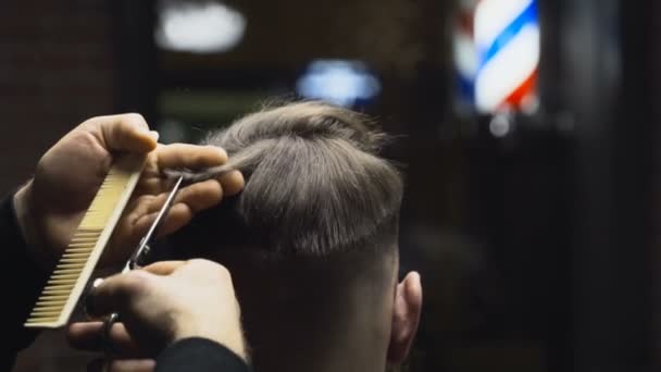 Barber coupe les cheveux du client avec des ciseaux au ralenti gros plan — Video