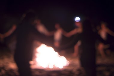 İnsanlar ateşin etrafında dans