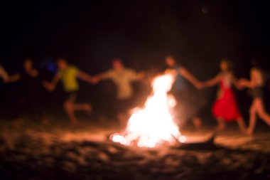 İnsanlar ateşin etrafında dans