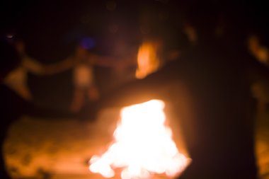 İnsanlar ateşin etrafında dans