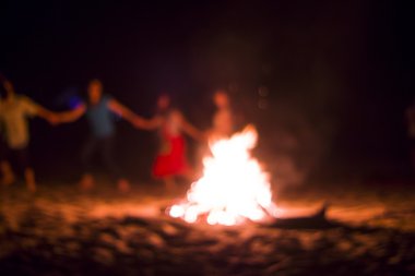 İnsanlar ateşin etrafında dans