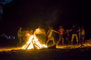 İnsanlar ateşin etrafında dans